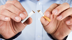 A person breaking a cigarette in half.